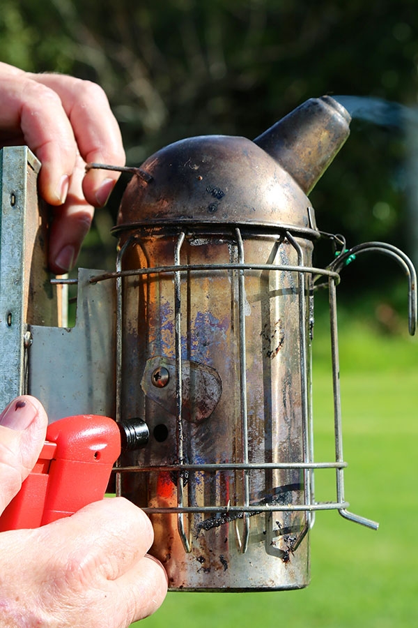 Smoker with hole and cover being lit